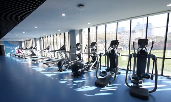 Yeni Nesil Fitness Salonları Üyelerine Neler Sunuyor Fitness sektörü son yıllarda büyük bir dönüşüm geçirirken, spor salonları da klasik antrenman alanlarından çok daha kapsamlı yaşam merkezlerine dönüşmeye başladı. Yeni nesil fitness salonları, yalnızca ağırlık kaldırılan veya kardiyo yapılan alanlar olmaktan çıkarak üyelerine teknoloji, kişisel takip, uzman desteği ve konfor odaklı hizmetler sunan modern merkezler haline geliyor. Bu değişimle birlikte fitness salonları, kullanıcıların hem fiziksel hem de yaşam tarzı hedeflerine ulaşmasını destekleyen daha profesyonel çözümler geliştiriyor. Konulu bir haber görseli.